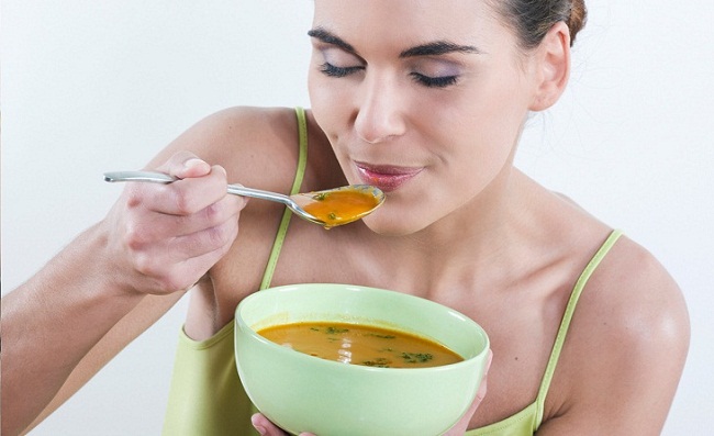 Женщина ест суп