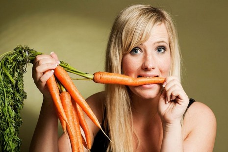 Девушка ест морковь